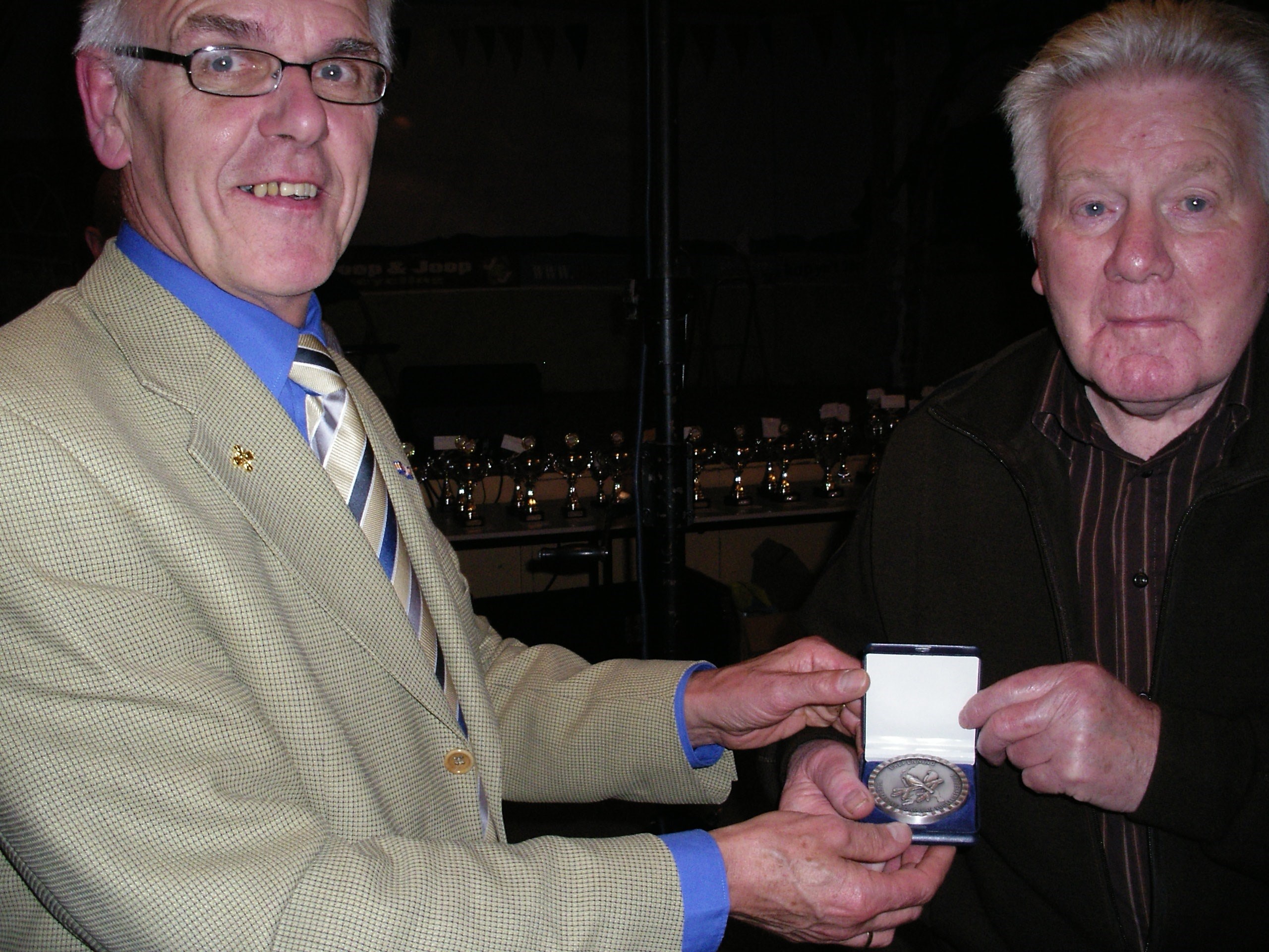 Koop Bakker krijgt de speld uitgereikt door de voorzitter van het District Friesland Dhr J de Haan